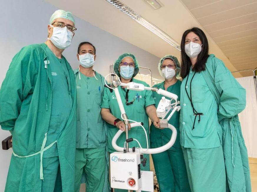 Surgical team pose with FreeHand cobot in Hospital Virgen del Puerto